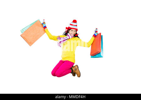 Felice ragazza adolescente In-Winter vestiti Jumping divertendosi con Shopping-Bags Foto Stock