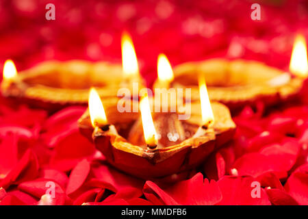 In primo piano il festival indiano illuminazione Diwali Diya, olio lampada Rose-Petals nessuno Foto Stock