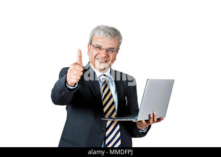 Un vecchio maschio di Business utilizzando laptop e mostra Thumbs up conquista il successo Foto Stock