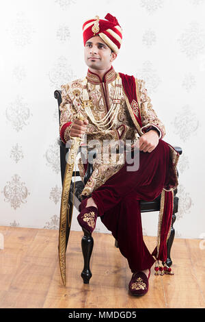 Una Royal Rajasthani groom seduta di nozze tradizionale Think-Memory Sherwani Foto Stock