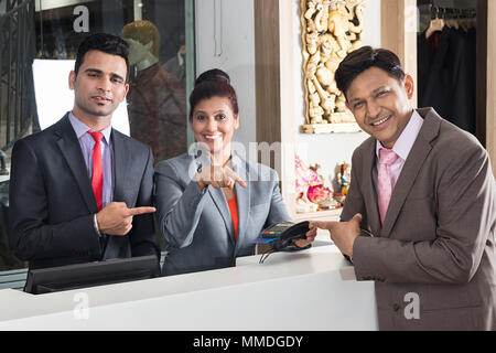 Indian man-Turismo Hotel stanza a pagamento mostra Debit-Card Reader Receptionist Reception Foto Stock