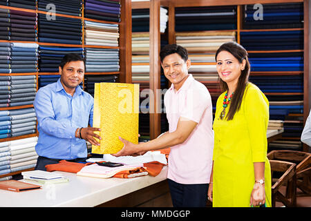 Venditore dando Shopping bag il cliente giovane acquisto di indumenti Market Store Foto Stock