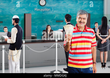 Un uomo anziano cliente mostrando la valuta indiana 500 rupie In-Bank note Foto Stock