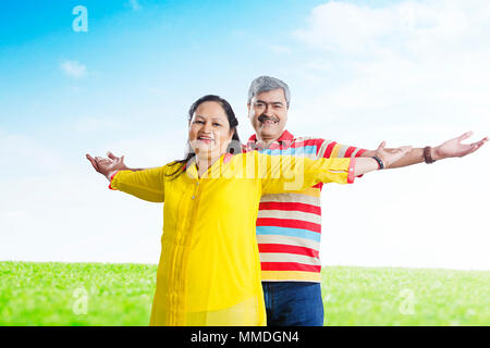 Due vecchie coppia sposata con Arms-Outstretched avendo divertimento allegro In-Park Foto Stock