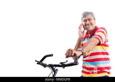 Felice un uomo anziano parlando al cellulare mentre in bicicletta Foto Stock