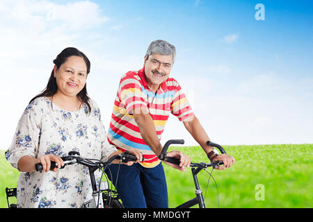 Indian Coppia di anziani insieme Bicicletta Equitazione Godetevi In-Park Foto Stock
