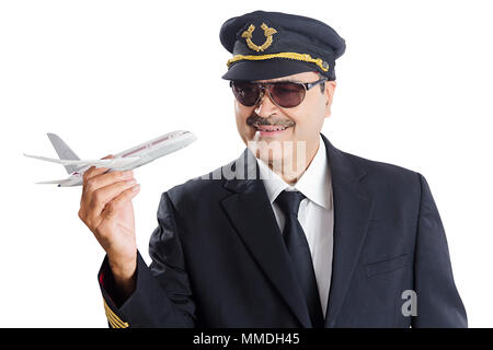 Sorridente un maschio pilota di linea tenendo un giocattolo in aereo determinazione Foto Stock