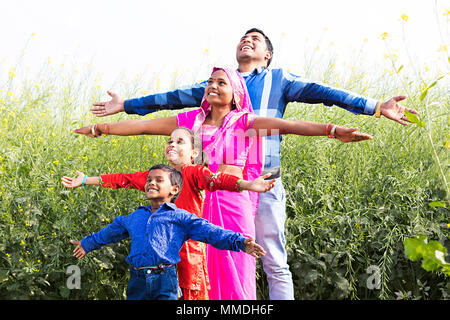 Felice villaggio rurale famiglia genitori e figli insieme Arms-Outstretched campo Foto Stock