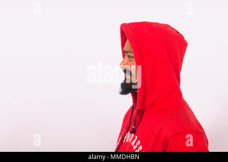 Giovane uomo che indossa felpa con cappuccio rosso. Posa laterale Foto Stock