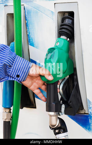 L'uomo della tubazione carburante in mano di pompaggio, industria. Pompa benzina station Foto Stock