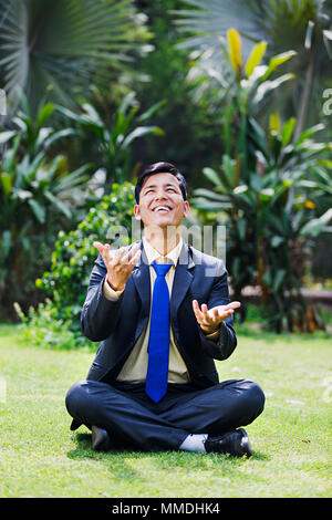 Un Business seduta maschio erba giocando Juggling godendo la cattura In-Garden Foto Stock