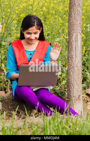 Abitante di villaggio rurale ragazza giovane con video-chat sul suo computer portatile In-Farm Village Foto Stock