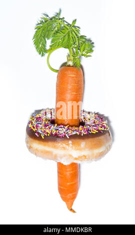Incollaggio di carota attraverso una ciambella Foto Stock