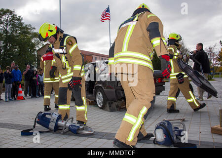 Vigili del fuoco assegnato all'US Army Garrison Ansbach stabilizzare un veicolo commerciale e utilizzare un divaricatore idraulico-cutter e altri strumenti di soccorso per assistere nella rimozione del tetto e "soccorso" dottor Marshall Blankenship il preside della scuola locale, che si presentano come una persona, intrappolata all'interno della vettura durante la prevenzione incendi settimana esercitano su di Ansbach High School, Ansbach, Germania, 11 ott. 2017. (U.S. Foto dell'esercito da Visual Information Specialist Eugen Warkentin) Foto Stock