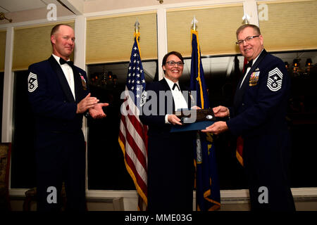 Montana Air National Guard comando Master Chief Sgt. Timothy Zumbrun applaude come centoventesimo Airlift Wing comando Master Chief Sgt. Steven Lynch presenta il 341 Ala Missile Command Chief Master Sgt. Ambra Mitchell con una placca durante il capo MTANG cerimonia di investitura tenutasi presso l'Meadowlark Country Club a Great Falls, Mont., Ottobre 14, 2017. (U.S. Air National Guard foto/Senior Master Sgt. Eric Peterson) Foto Stock