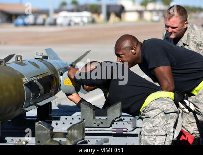 Stati Uniti Air Force Airman 1. Classe Najeeb Travis (sinistra), e lo Staff Sgt. Christopher Holmes (centro), degli aeromobili Sistemi di armamento tecnici dall'325Manutenzione aeromobili squadrone, esaminare la parte della formazione di una bomba durante un carico equipaggio del quarto concorso al Tyndall Air Force Base Fla., 13 ottobre, 2017. Come team di piombo, Holmes diretto il caricamento di più sistemi di armamenti su di un F-22 Raptor ed è stato responsabile per la verifica di tutte le sfaccettature sono completati. (U.S. Air Force foto di Airman 1. Classe Isaia J. Soliz/rilasciato) Foto Stock