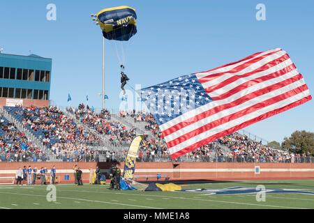 171023-N-pp996-196 Giosuè, Texas (ott. 23, 2017) in pensione Navy SEAL Jim Woods, membro dell'U.S. Navy parachute team, il salto delle rane, presenta la nostra nazione è bandiera come egli si prepara a terra durante un paracadute di dimostrazione a Giosuè di alta scuola del gufo Stadium come parte del Navy settimana Fort Worth 2017. Navy settimana servono programmi come la Marina Il principale sforzo di divulgazione nelle aree del paese senza una significativa presenza della Marina. (U.S. Foto di Marina di Massa lo specialista di comunicazione di terza classe Danny Kelley/rilasciato) Foto Stock