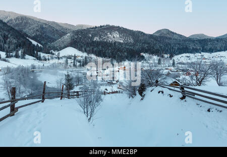 Lo spuntar del giorno mattina inverno tramonto dei Carpazi villaggio di montagna Zelene in nero Cheremosh river valley tra alp. Vista dalla campagna coperta di neve percorso sulla collina Foto Stock