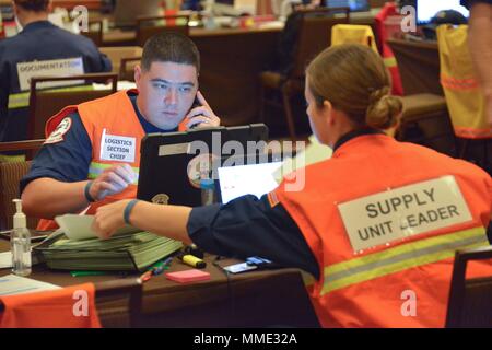 Stati Uniti Coast Guard Chief Warrant Officer Stephen Vescovo, la logistica il capo della sezione, e sottufficiali di seconda classe Cassidy Stevens, l'unità di alimentazione leader, Risorse ordine all'uragano Maria FSE-10 PR comando unificato Incident Command Post in San Juan, Puerto Rico, 20 ott. 2017. La Maria FSE-10 PR comando unificato, consistente del dipartimento delle risorse naturali e ambientali, U.S. Coast Guard in congiunzione con il Porto Rico della qualità ambientale Scheda di controllo, Agenzia di protezione ambientale e di Stati Uniti e Fish & Wildlife Service, risponde alle navi trovato essere danneggiato, Foto Stock