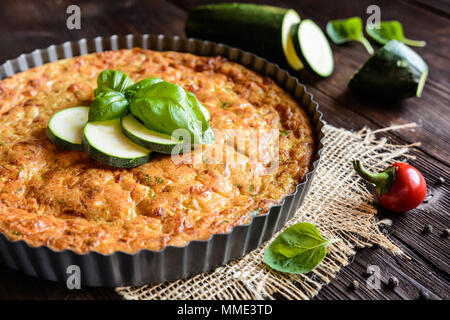Tortino di zucchine con pancetta e formaggio, cipolla, prezzemolo e basilico Foto Stock