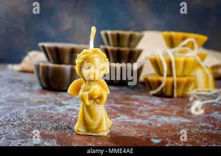 Naturale candela di cera d'api in forma Angelo, a mano delle candele artigianali, realizzato per vacanza, arte e salute su sfondo scuro, copia spase Foto Stock