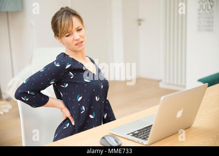 Donna con dolori alla parte inferiore della schiena Foto Stock