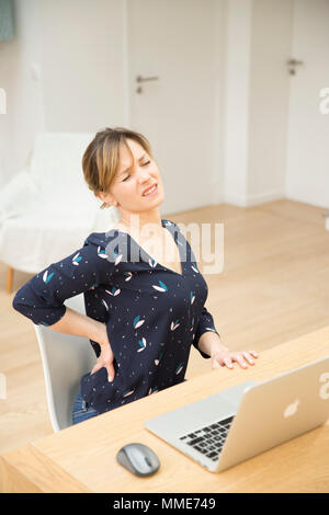 Donna con dolori alla parte inferiore della schiena Foto Stock