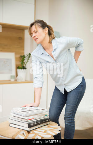 Donna con dolori alla parte inferiore della schiena Foto Stock