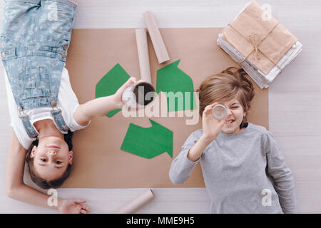 Elevato angolo di kids giacente sulla carta durante la tutela ambientale le classi a scuola Foto Stock