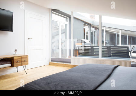 Elegante camera da letto interno con una grande finestra con vista terrazza Foto Stock