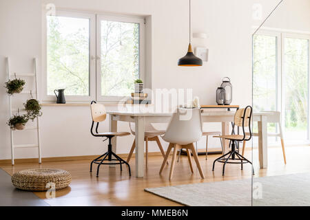 Bianca e moderna sala da pranzo con un grande tavolo e sedie di design Foto Stock
