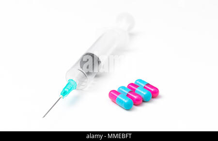 Il concetto di medicina. pillole colorate e la siringa su sfondo bianco Foto Stock