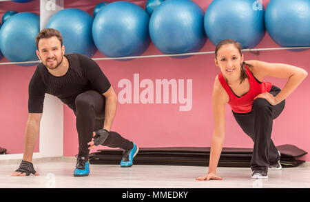 Coppia giovane facendo esercizi di stretching in palestra Foto Stock