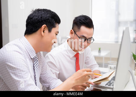 Immagine di due giovani imprenditori che interagiscono su riunione in ufficio Foto Stock