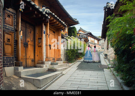 Indietro di due donna che indossa hanbok camminando attraverso lo stile tradizionale delle case di il villaggio di Bukchon Hanok a Seul, in Corea del Sud. Foto Stock