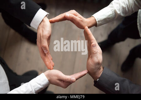 La gente di affari unire le mani in cerchio e di protezione e sostegno con Foto Stock