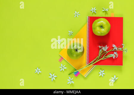 Molti blossom le teste dei fiori ornithogalum e di rosso e di giallo notebook con bouquet, verde mela succosa sul verde brillante superficie. Foto Stock