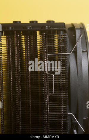 La ventola della CPU dello scambiatore di calore del processore su sfondo giallo Foto Stock