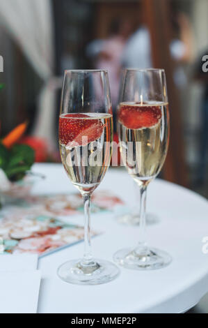 Con una bottiglia di champagne e fragole su un party Foto Stock