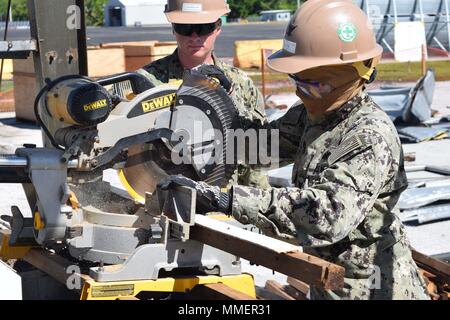 171024-N-FT956-0566 Diego Garcia, Territorio britannico dell'Oceano Indiano (ott. 24, 2017) Builder di terza classe di Michael Johnson (sinistra) osserva Steelworker 3° di classe Alisha Silva (destra), assegnato alla Naval Mobile Battaglione di costruzione (NMCB) 4, come ella tagli di materiale da un edificio demolito a pila su pallet da rimuovere da un sito web del progetto. NMCB 4 è distribuito per la 7a Flotta Area di responsabilità a sostegno dell assistenza umanitaria/Disaster Relief Operations e per fornire al generale di ingegneria civile e di sostegno per gli Stati Uniti La marina e le forze alleate.(US Navy foto di builder di 2a classe di Christopher Mo Foto Stock
