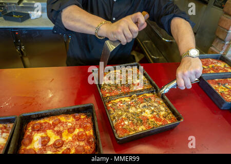 Un pizzaiolo rimuove un fungo sormontato stile di Detroit deep dish pizza dal suo pan alla recente apertura di Lions & Tigers & piazze pizzeria nel quartiere di Chelsea di New York il giorno di apertura, martedì 1 maggio 2018. (Â© Richard B. Levine) Foto Stock