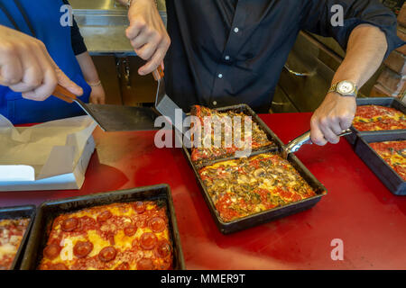 Un pizzaiolo rimuove un fungo sormontato stile di Detroit deep dish pizza dal suo pan alla recente apertura di Lions & Tigers & piazze pizzeria nel quartiere di Chelsea di New York il giorno di apertura, martedì 1 maggio 2018. (© Richard B. Levine) Foto Stock