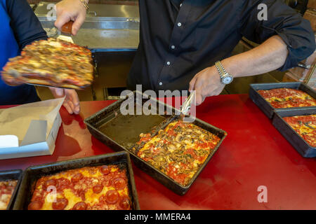 Un pizzaiolo rimuove un fungo sormontato stile di Detroit deep dish pizza dal suo pan alla recente apertura di Lions & Tigers & piazze pizzeria nel quartiere di Chelsea di New York il giorno di apertura, martedì 1 maggio 2018. (© Richard B. Levine) Foto Stock