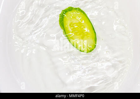 Cetriolo fresco con acqua in una piastra bianca Foto Stock