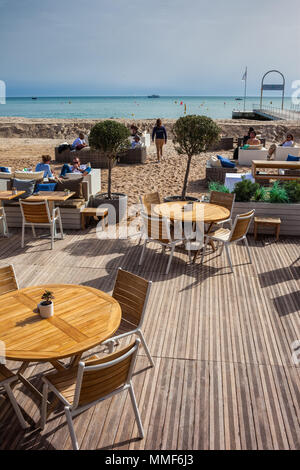 Beachfront cafe ristorante tavoli sulla Riviera francese a Cannes, Francia, spiaggia sulla Costa Azzurra al Mare Mediterraneo Foto Stock