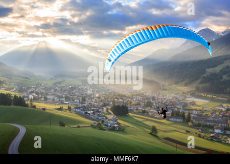 Il parapendio in aria in un piccolo paese di montagna Foto Stock