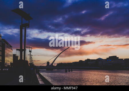 Dublino, Irlanda - 9 Maggio 2018: Majestic arancione e rosa tonica tramonto sul fiume Liffey a Dublino, dotato di Samuel Beckett bridge Foto Stock