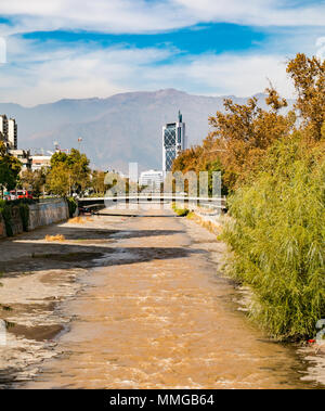 Fiume Mapocho, con poca acqua che fluisce a fine estate e torre di telefono a distanza, Santiago del Cile Foto Stock