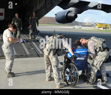 Cittadino di riserva aviatori assegnati per il quarantacinquesimo di medicina aeronautica squadrone di evacuazione, aiutare un paziente a bordo di una C-17 Globemaster III in St. Croix, U.S. Isole Vergini, Sett. 24, 2017. Cittadino di riserva aviatori condotta missione umanitaria di St. Croix per evacuare le vittime colpite dall'uragano Maria. (U.S. Air Force foto di Tech. Sgt. Peter Dean) Foto Stock