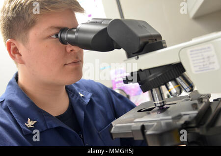 KINGS BAY, Ga. (Ott. 24, 2017) Ospedale Corpsman 3rd Class Robert Hall studi un campione di sangue con un microscopio a ramo navale Health Clinic Kings Bay il laboratorio. Attraverso il nostro ospedale e cinque filiali Clinics di Salute, abbiamo condotto 1,355,867 di test di laboratorio per l'anno fiscale 2017. (U.S. Navy foto di Giacobbe Sippel, Ospedale Navale di Jacksonville/RILASCIATO). Foto Stock